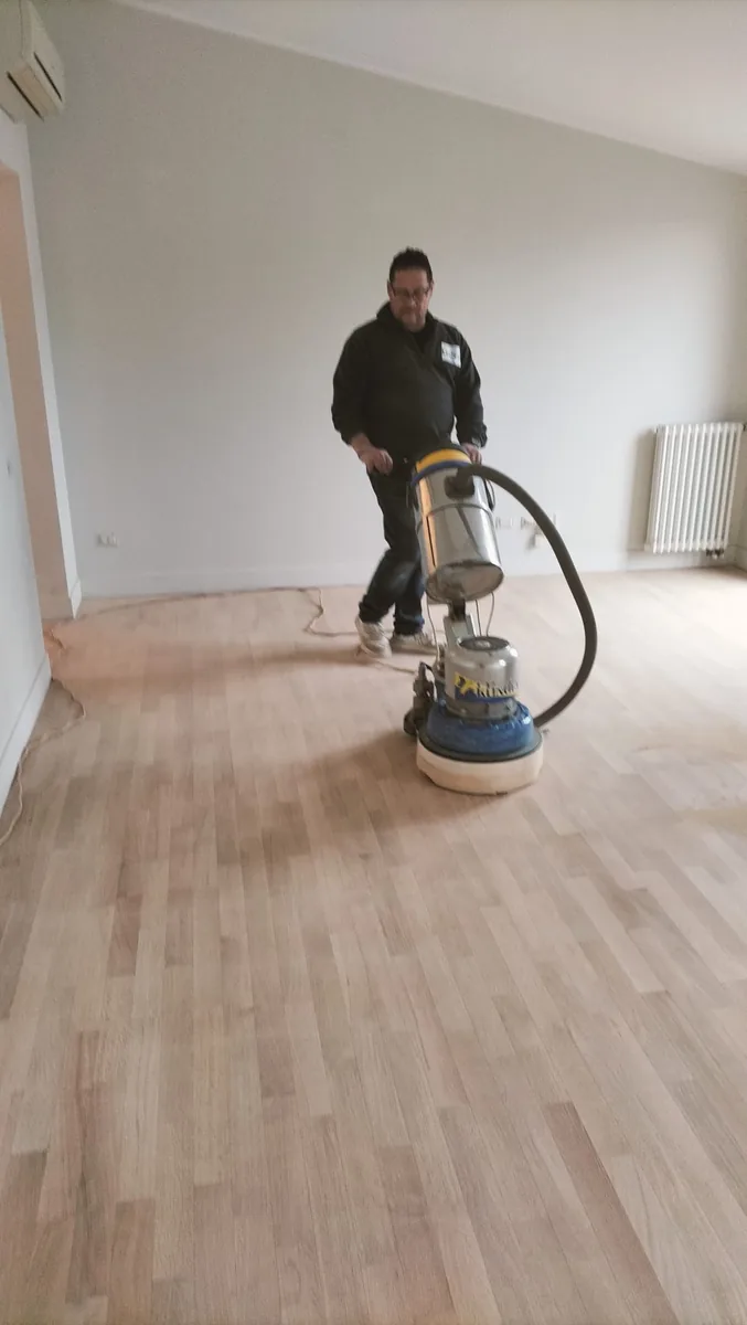 Antonio leviga un pavimento in legno con la macchina levigatrice